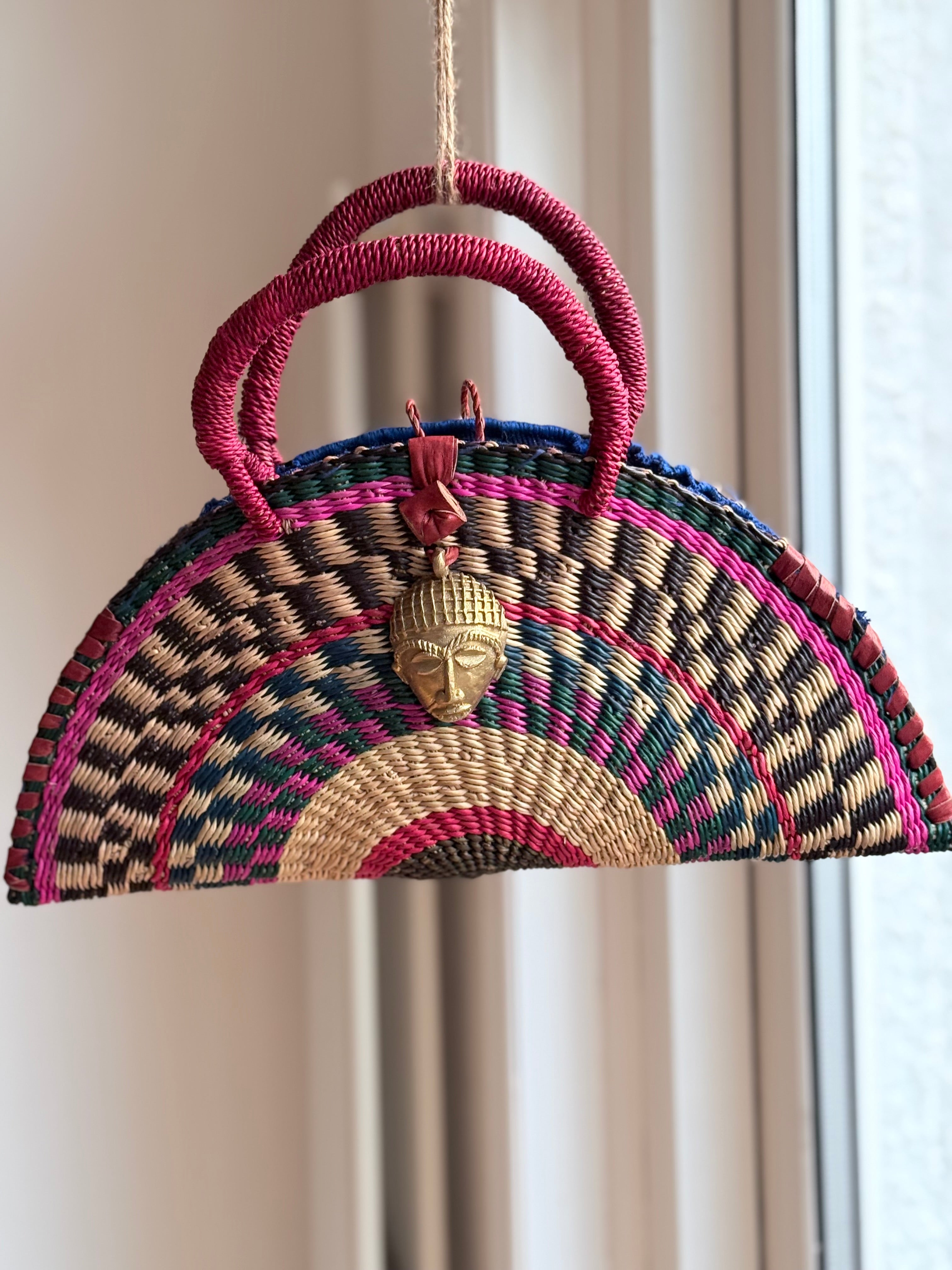 African Handwoven Half-Moon Bag with Brass Mask Pendant & Red Handles